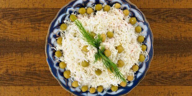 Под картошку он разлетается мгновенно: рецепт слоеного салата с килькой в томате