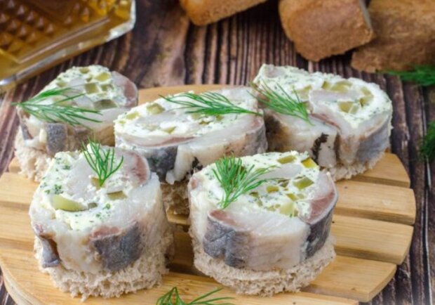 И для застолья, и на выходные: рецепт рулетиков из селедки с сыром и оливками